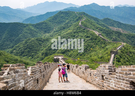Mutianyu, China - Landscape view of tourists taking pictures and walking on the Great Wall of China. The wall stretches over 6,0