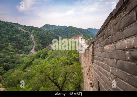 Mutianyu, China - Landscape view of tourists taking pictures and walking on the Great Wall of China. The wall stretches over 6,0