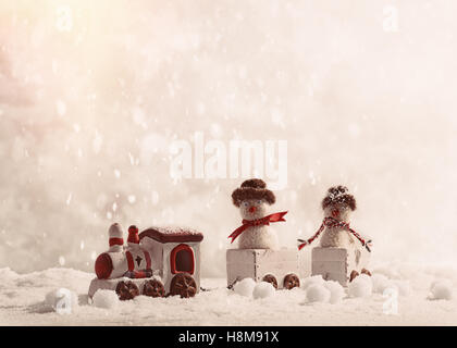 Snowmen sitting in toy train set at Christmas in the snow Stock Photo