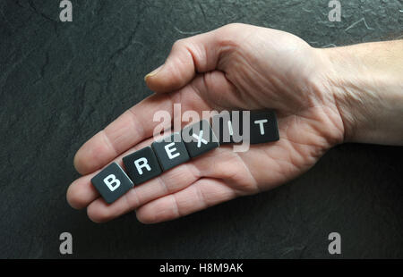 MANS HAND WITH WORD TILES SPELLING 'BREXIT' RE BREXIT THE EU LEAVING REFERENDUM VOTE THE EUROPEAN UNION LEAVE CAMPAIGN GB UK Stock Photo