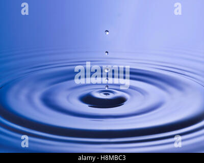 Drop hitting surface of water close-up Stock Photo