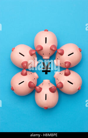 Piggy banks surrounding a Yen Yuan symbol view from above Stock Photo