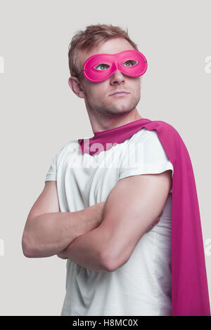 Superhero wearing pink cape and mask Stock Photo