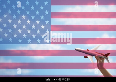 Toy plane flying in front of US flag Stock Photo