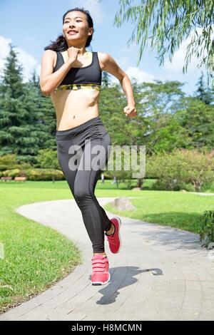 Fit and Healthy Chinese woman running in park Stock Photo