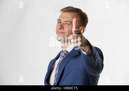 Businessman winking and pointing to camera Stock Photo