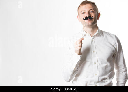 Portrait of an attractive young man wearing a retro style fake mustache. Stock Photo