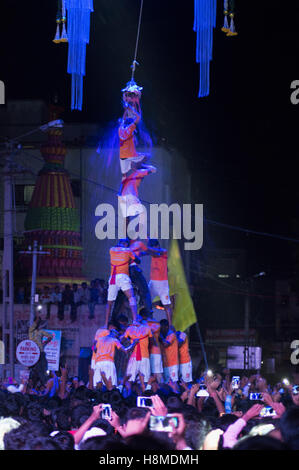 Human pyramid broken dahi handi shower of curd and turmeric water on janmashtami festival, Pune Stock Photo