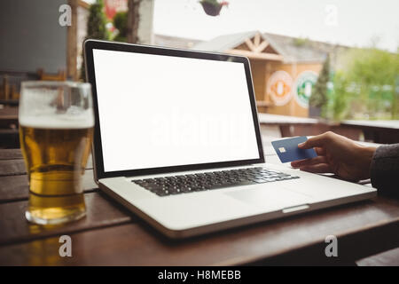 Man doing online shopping with credit card on laptop Stock Photo