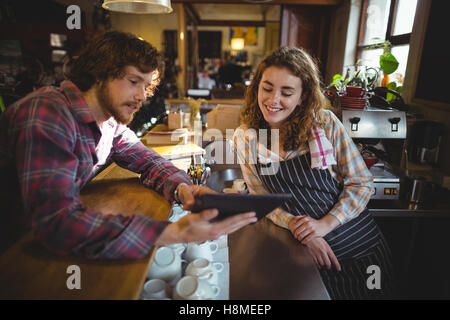 Customer showing digital tablet to waitress Stock Photo