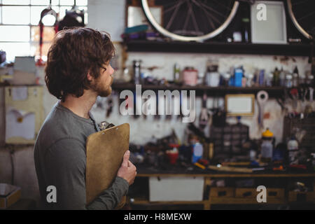 Mechanic standing with clipboard Stock Photo