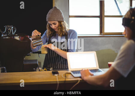 Waitress preparing coffee at counter Stock Photo