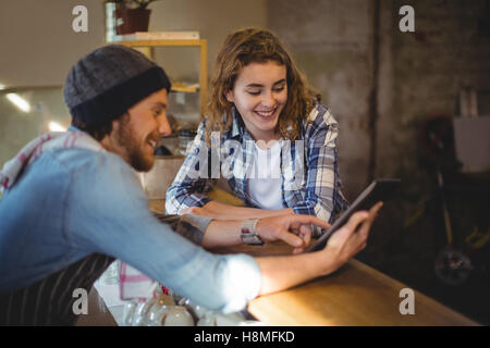 Mechanic and waiter using digital tablet at counter Stock Photo
