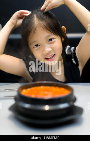 Asian kid with traditional Korean Kimchi soup. Stock Photo