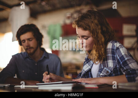 Beautiful mechanic writing in diary Stock Photo