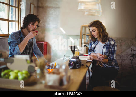 Mechanic and waiter having coffee at counter Stock Photo