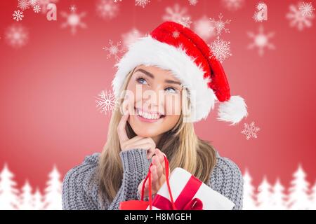 Smiling woman in santa hat holding a gift bag Stock Photo