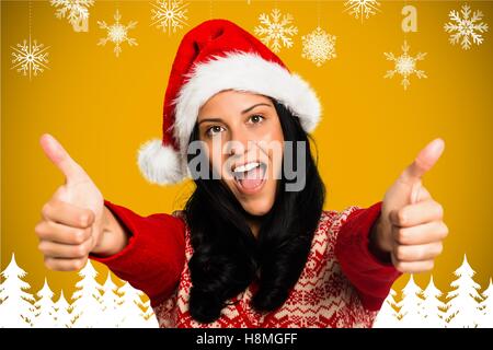 Portrait of beautiful woman in santa hat giving thumbs up Stock Photo