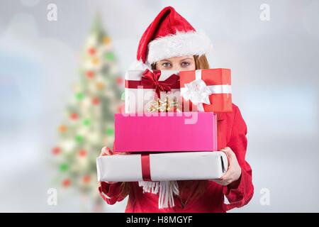 Woman in santa hat holding stack of gifts Stock Photo