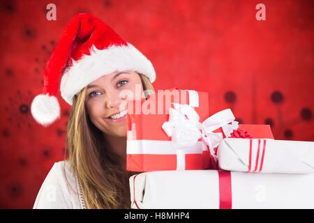 Smiling woman in santa costume holding stack of christmas gifts Stock Photo