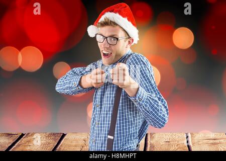 Man in santa hat gesturing against digitally generated background Stock Photo
