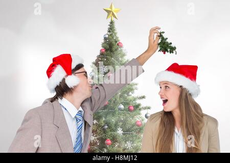 Playful couple in santa hat standing near christmas tree Stock Photo