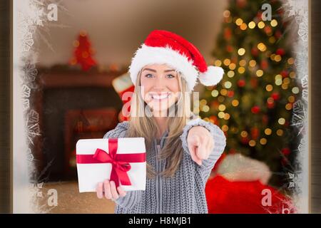 Beautiful woman in santa hat holding a christmas gift Stock Photo