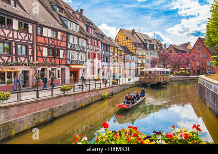 Beautiful view of the historic town of Colmar, also known as Little Venice, with tourists taking a boat ride on canal, Alsace region, France Stock Photo