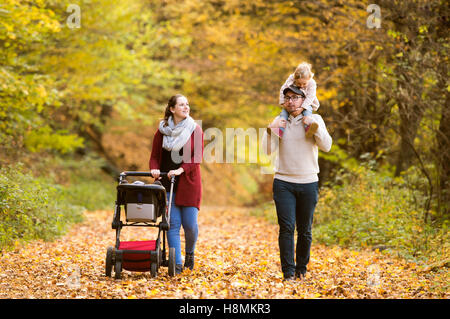 Beautiful young family on a walk in autumn forest. Stock Photo