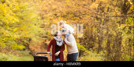 Beautiful young family on a walk in autumn forest. Stock Photo