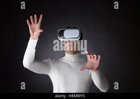 Man wearing virtual reality goggles and pointing fingers to empty space Stock Photo