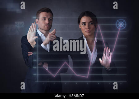 Business people touching a graph indicating growth on virtual display Stock Photo