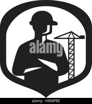 Illustration of a silhouette of a builder construction worker with folded arms  set inside shield crest with boom crane in the b Stock Vector