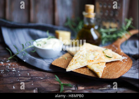 Focaccia with olive oil, parmesan cheese, white sause and rosemary. Homemade traditional Italian bread focaccia on the linen nap Stock Photo