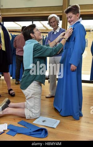 Boy and girl choristers of Wells Cathedral Choir at cassock fitting before rehearsing for evensong. Stock Photo