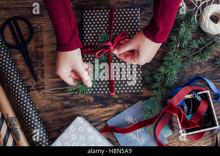 Woman Tying Ribbon on Christmas Present Stock Photo