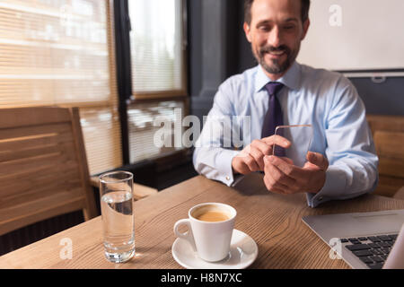 Happy positive man using an electronic device Stock Photo