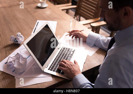 Calm hard working man pressing buttons on the keyboard Stock Photo