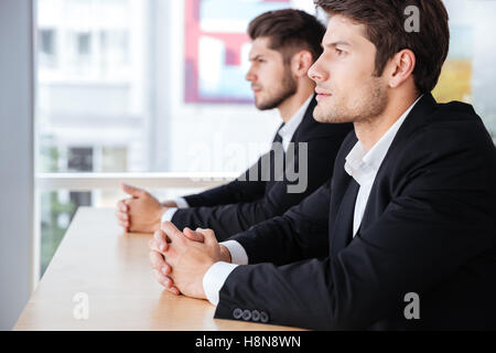 Profile of two confident young businessmen sitting in office Stock Photo