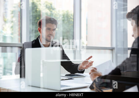Two handsome young businessmen with laptop on business meeting Stock Photo