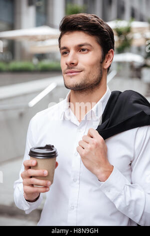 Portrait of attractive young businessman drinking coffee outdoors Stock Photo