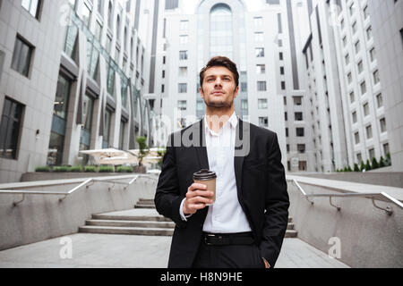 Serious young businessman drinking take away coffee in the city Stock Photo
