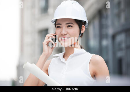 Chinese female architect talking on cell phone Stock Photo