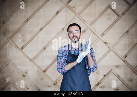 Portrait of a carpenter working in workshop wearing gloves Stock Photo