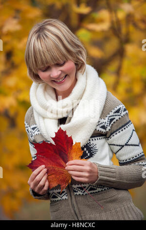 Young woman holding a large leaf Stock Photo - Alamy