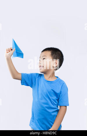 Happy little Chinese boy throwing a paper airplane Stock Photo