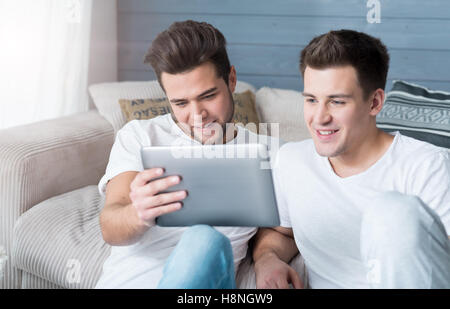 Two young handsome men using tablet. Stock Photo