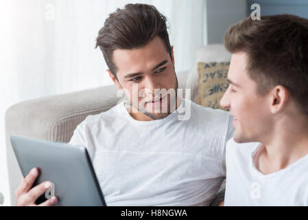 Pleasant gay couple using tablet. Stock Photo