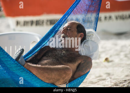 Man sleeping in a hammock on the beach Stock Photo