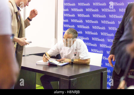 Michel Roux Jr signs his book for a fan during the BBC Good Food Show at Olympia London. Stock Photo